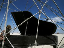 Burning Man participant Wardley plays the Baby Grand piano inside the 'Heardt' art project at the Burning Man festival in the Black Rock Desert of Nevada, U.S.