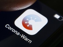 Die Corona-Warn-App wird auf dem Display eines Smartphones angezeigt. Die App soll helfen Infektionsketten des SARS-CoV